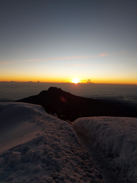       Sunset view from a snowy mountain peak.
  