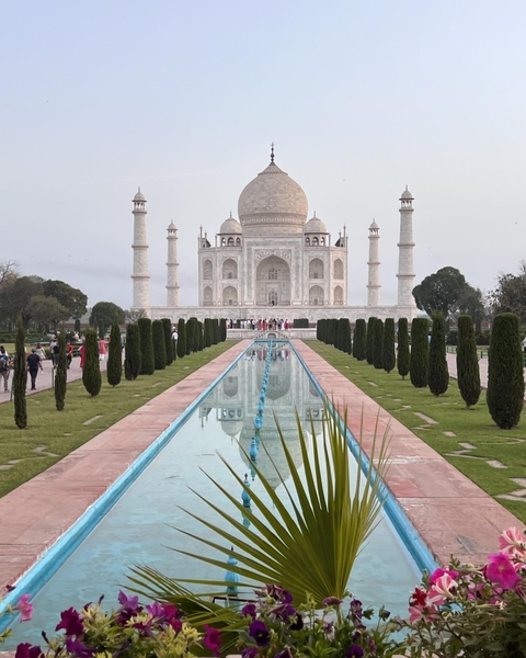 Taj Mahal with reflecting pool and tourists.