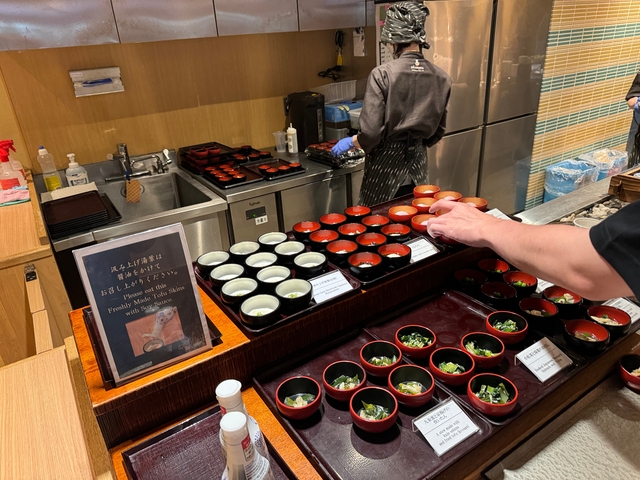 A restaurant kitchen counter with traditional Japanese dishes.
