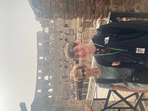 Two people posing in front of the Colosseum.