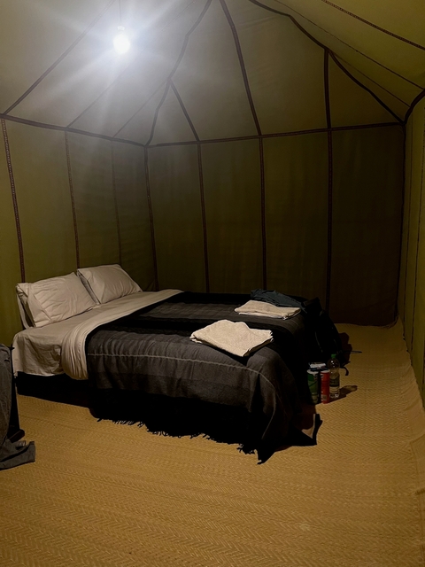 Interior of a lodging with bed and towels.