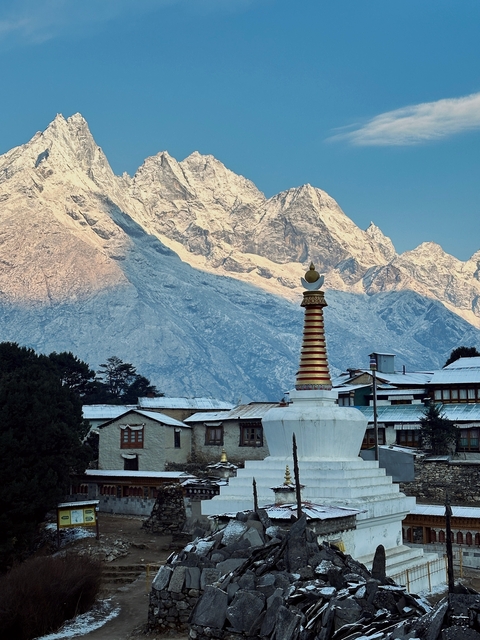 Buddhist stupa with a snow-covered mountain backdrop.