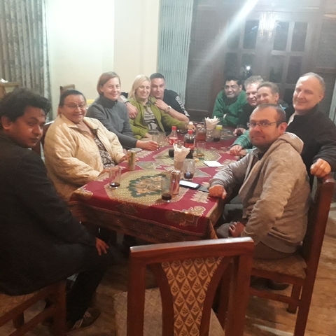 Group of people sitting around a dining table indoors.