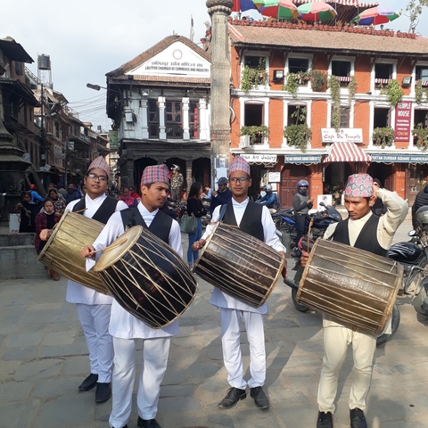 Musicians in traditional attire playing drums during a festival.