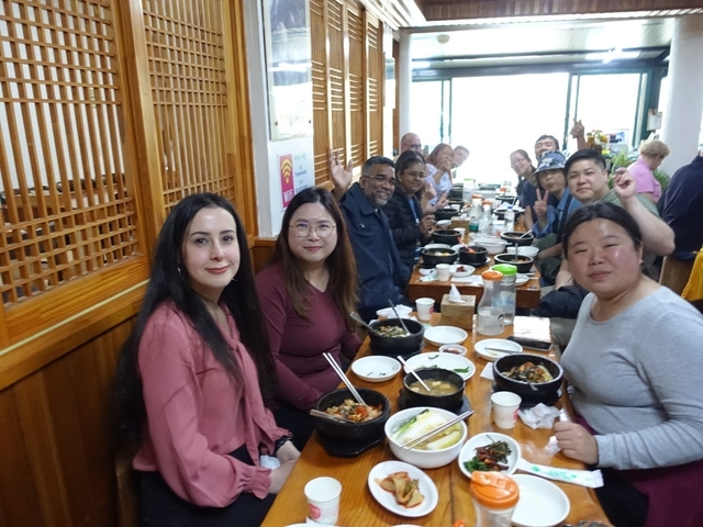 Group of people dining at a long table in a restaurant.