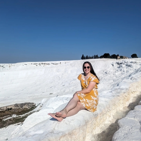 Woman sitting by the white travertine terraces.