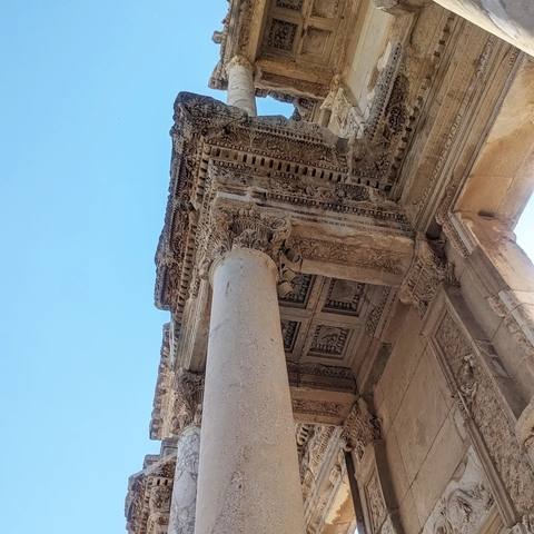 Close-up of intricately carved ancient stone columns and roof.
