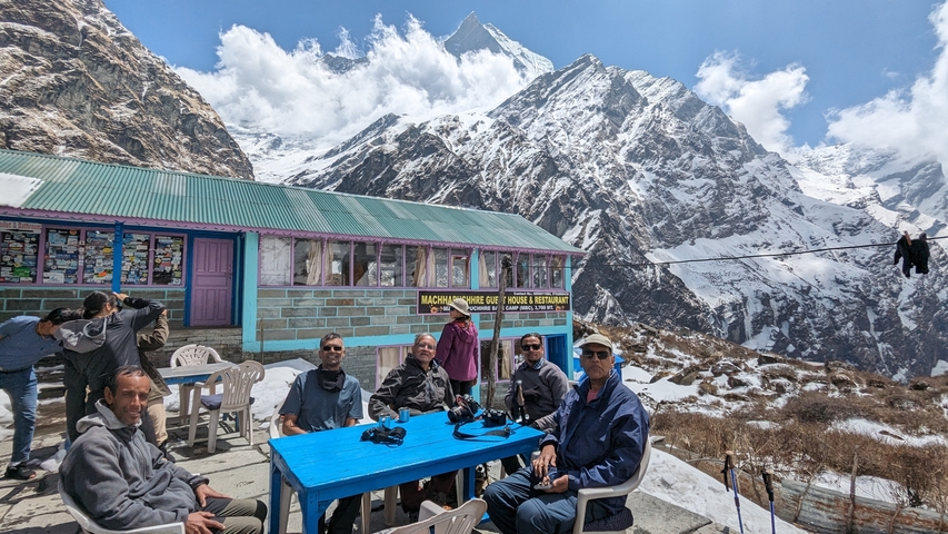Group of people sitting at a table in the mountains.