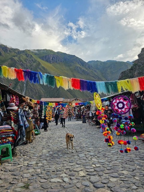 Colorful market with traditional textiles and crafts on a mountain backdrop.