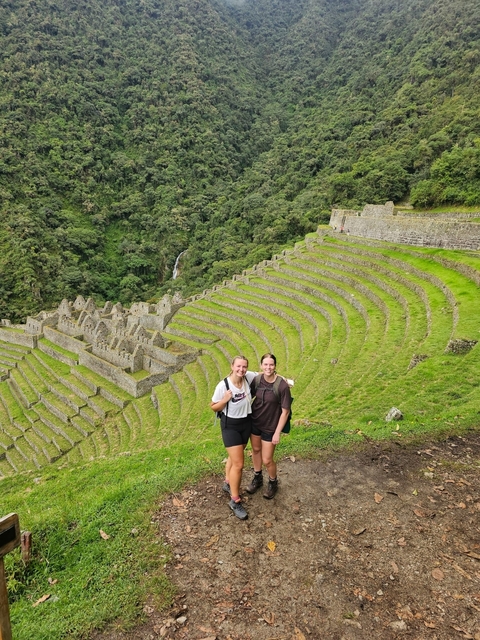 Two people posing in front of impressive ancient terraces.