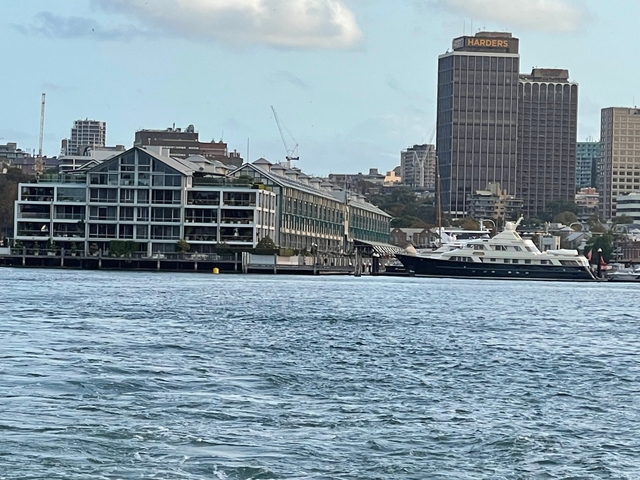 Buildings lining the waterfront with a yacht.