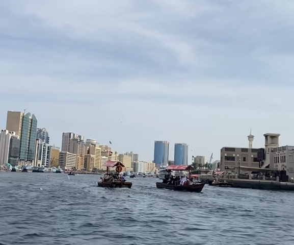 Urban waterway with boats and modern skyscrapers.