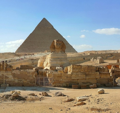 Famous ancient Sphinx statue before a large pyramid.