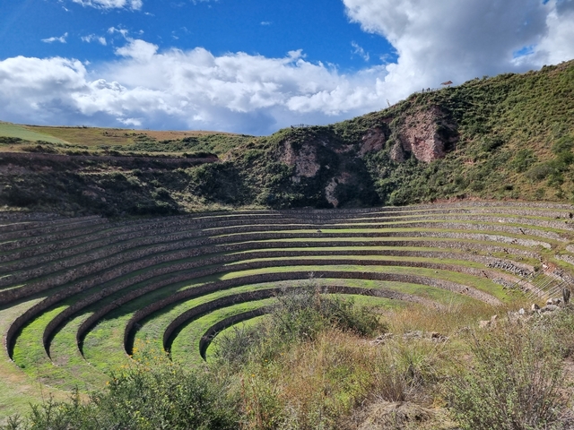      Circular terraced landscape under a cloudy sky.
  