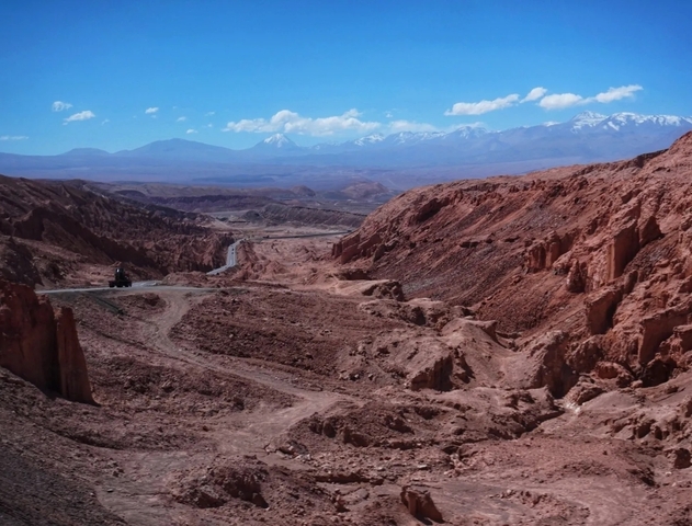 Rugged terrain with mountains under a clear sky.