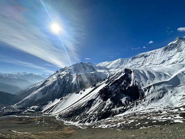       Snow-covered mountain landscape with bright sun.
  
