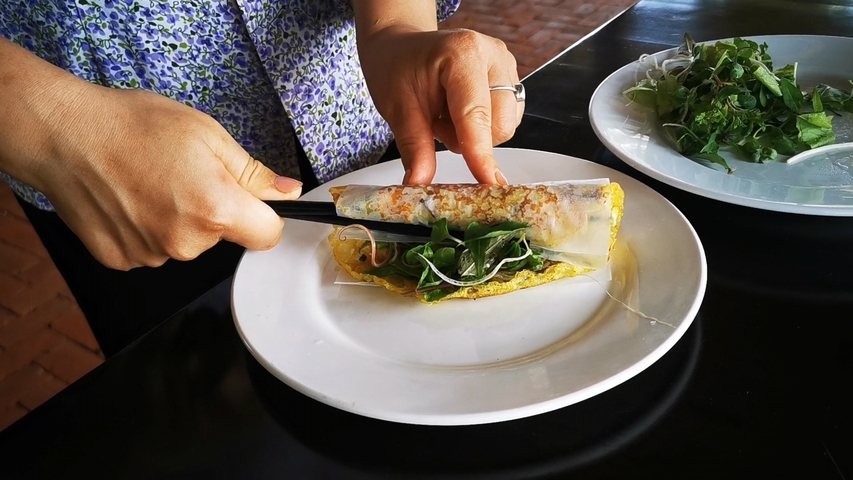       A person preparing Vietnamese spring rolls.
  