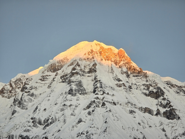 Snow-covered mountain under a clear sky.