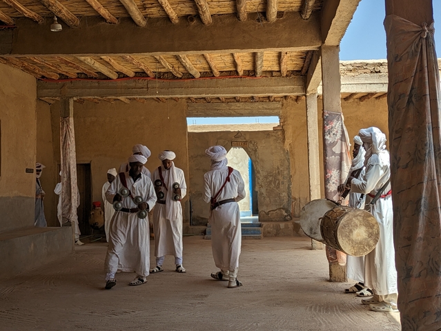 Group of people in traditional attire posing indoors.