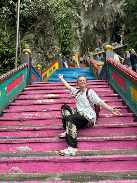       Woman on colorful steps, smiling with open arms.
  
