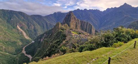 Panoramic view of Machu Picchu with surrounding mountains.