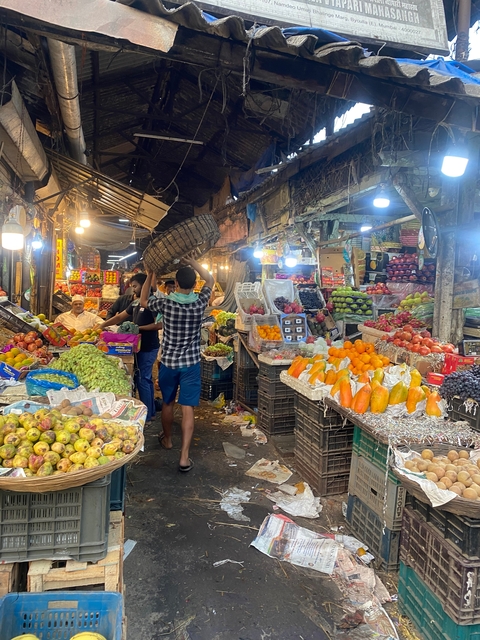 Market scene with various fruits and vendors.