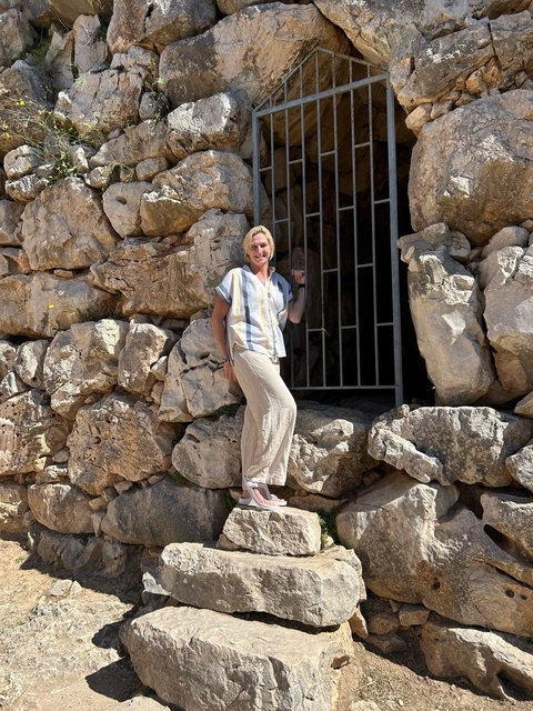 Person posing near ancient stones.