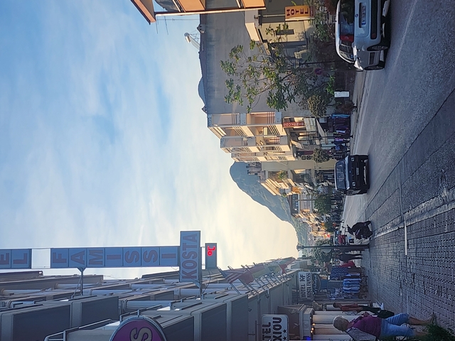       Street view with buildings and a mountain in the background.
  