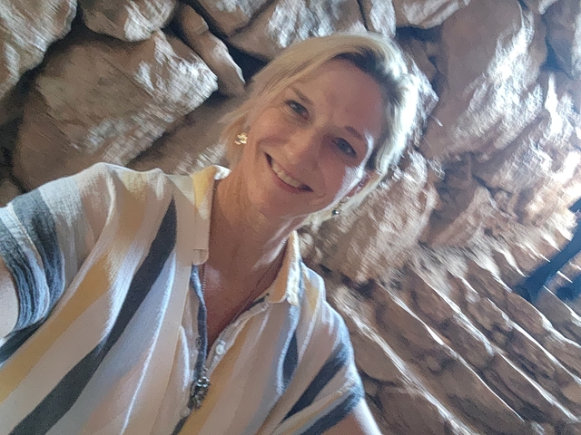       Person taking a selfie in a rocky environment.
  