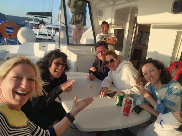       Group of people on a boat sailing on a sunny day.
  