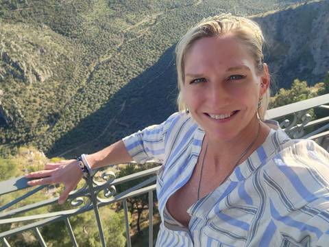       Person taking a selfie with a mountainous landscape in the background.
  