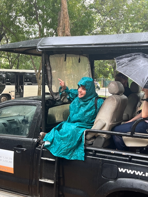 Person in a raincoat sitting in a vehicle during rain.