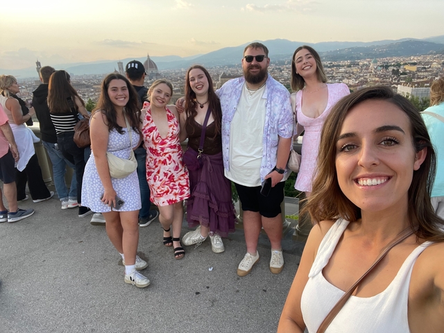 Group of young adults posing with Florence's skyline in the background.
