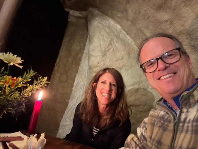 Couple smiling with candlelight and decorative flowers.