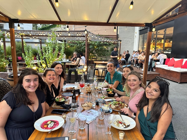 Group of people enjoying a meal at a lively outdoor setting.
