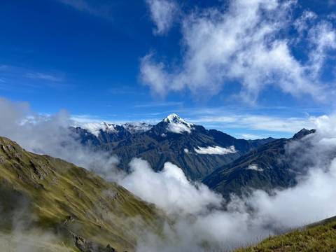 Snow-capped mountain with clouds surrounding the peak.