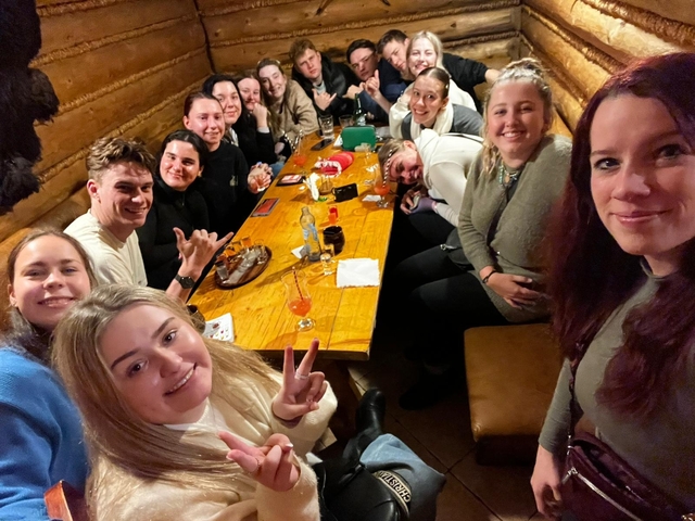 A group of people in a cozy indoor setting, enjoying drinks.