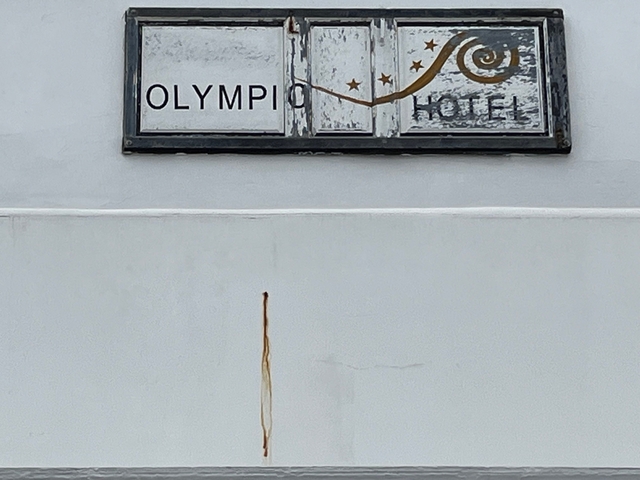 Olympic Hotel sign on a white wall.