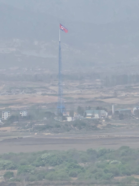 Distant view of a flat landscape with a tall structure.