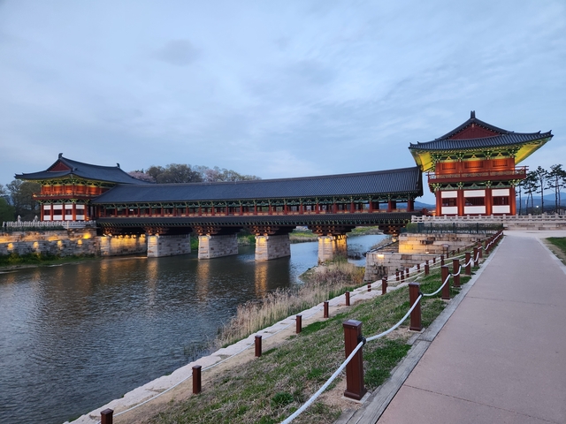 Traditional Korean bridge illuminated over a river.