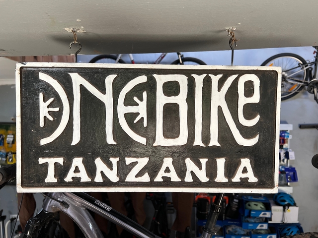 Sign reading 'One Bike Tanzania' in a shop setting.