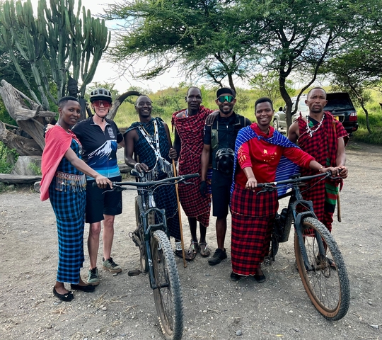 Group of cyclists with traditional clothing posing together.