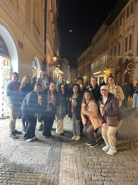 Group of people holding ice cream at night in the street.