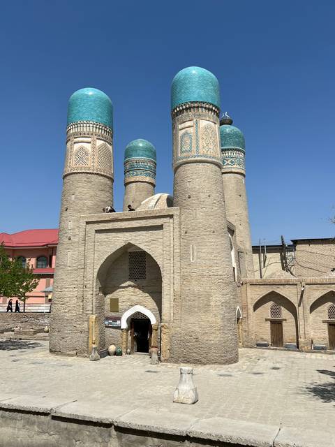       Ancient architecture with blue domes and three tall minarets.
  