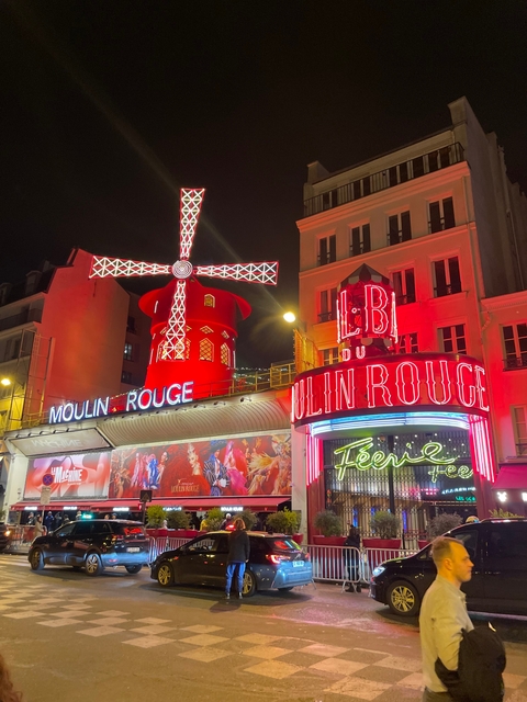The iconic Moulin Rouge at night with bright red lights.