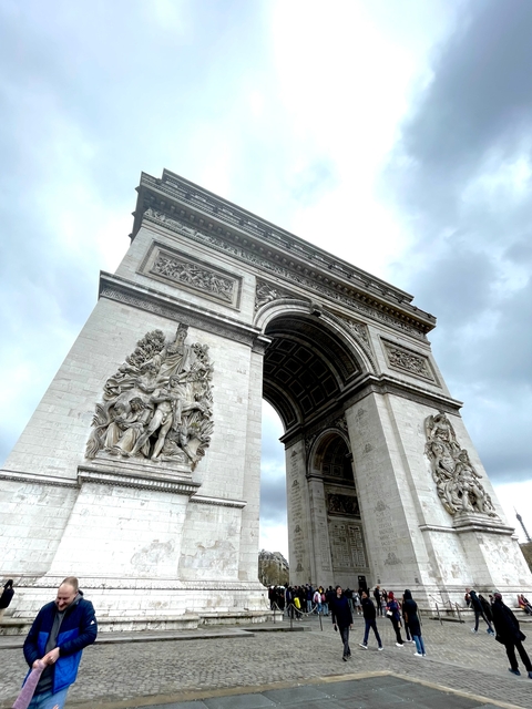 Close-up view of the Arc de Triomphe looking upward.