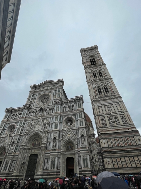 The Florence Cathedral and Giotto's Campanile against a cloudy sky.