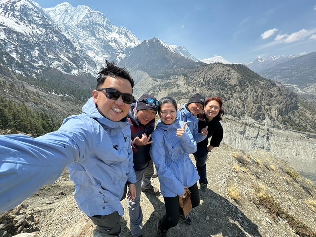 Group selfie with a backdrop of mountains and a valley.