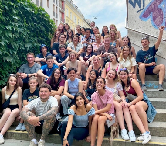 A large group of people sitting and posing together on steps.