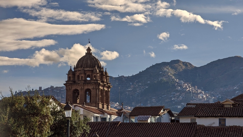A scenic view of a church with mountains in the background.